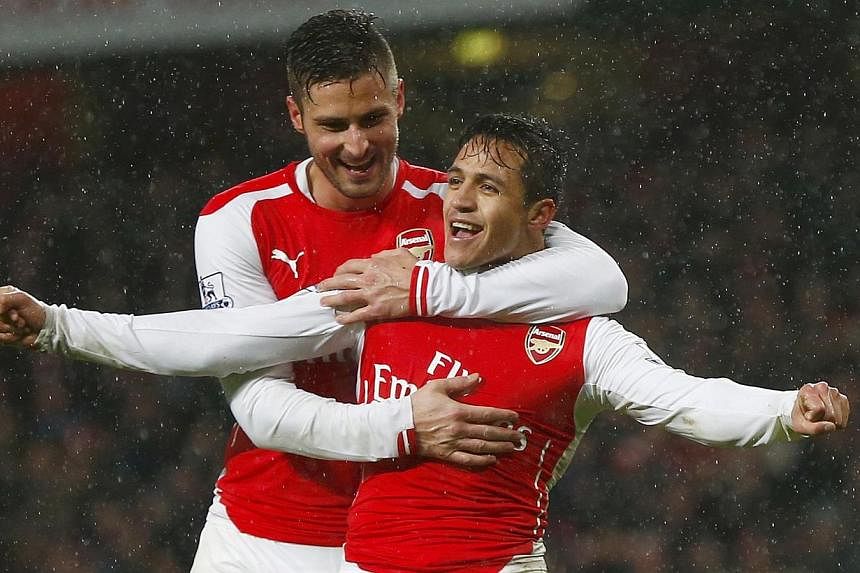 Arsenal's Alexis Sanchez (front) celebrates with team-mate Olivier Giroud after scoring a goal against Queens Park Rangers during their English Premier League soccer match at the Emirates Stadium in London Dec 26, 2014. -- PHOTO: REUTERS