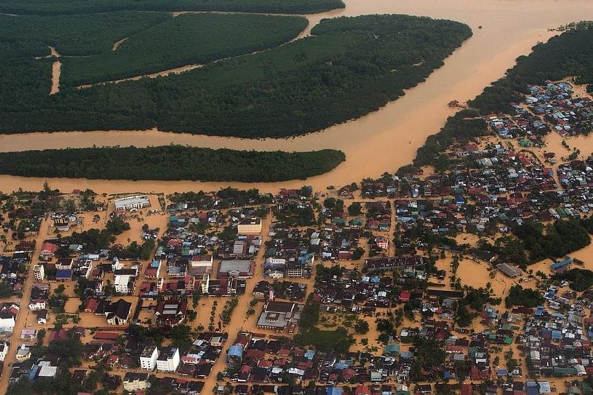 This aerial view shows houses and plantations submerged in floodwaters in Pengkalan Chepa, near Kota Bharu on Dec 27, 2014. -- PHOTO:AFP