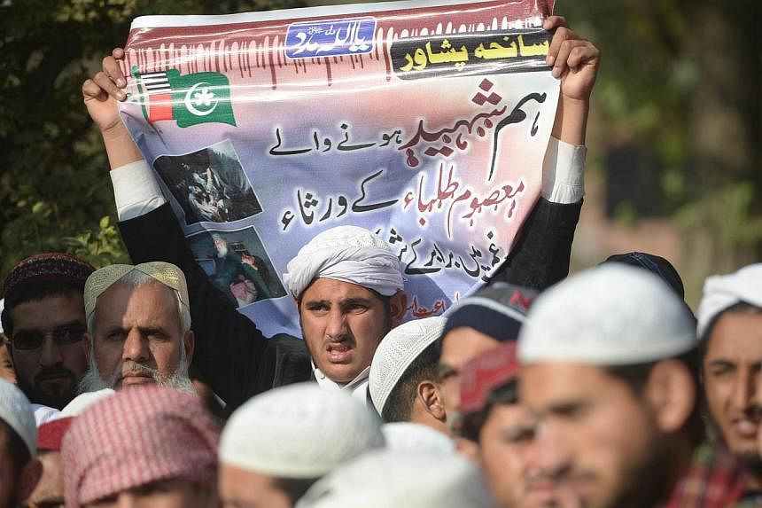 Pakistani Islamists gather for the victims of the Peshawar school massacre in front of the radical Red mosque after congregational Friday prayers in Islamabad on Dec 19, 2014. -- PHOTO: AFP