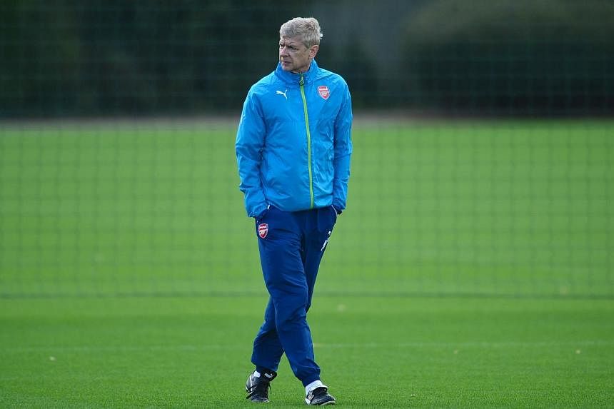 Arsenal's French manager Arsene Wenger attends training at their London Colney facility in Hertfordshire, north of London on Oct 21, 2014. He&nbsp;admits losing Oliver Giroud once again is a body blow to Arsenal's Champions League push. -- PHOTO: AFP