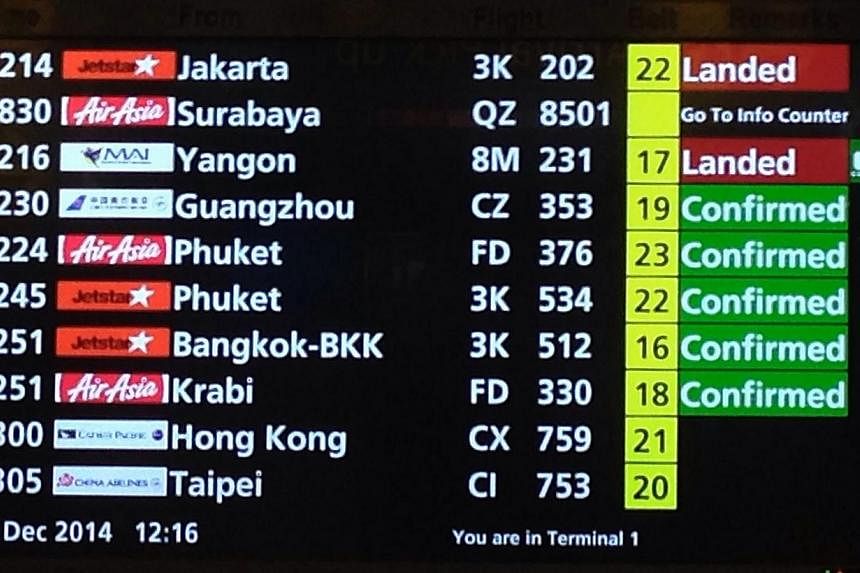 The electronic screen at Terminal 1 arrival hall showing the details of the AirAsia flight QZ8501 bound for Singapore from Surabaya that lost contact. -- ST PHOTO: NEO XIAOBIN
