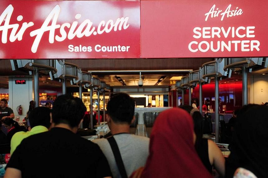 People queue at an AirAsia sales counter in terminal 1 at Changi international airport in Singapore on Dec 28, 2014.&nbsp;An illness of the family patriarch led to the Singapore trip of one Indonesian family being cancelled - and in turn saved their 