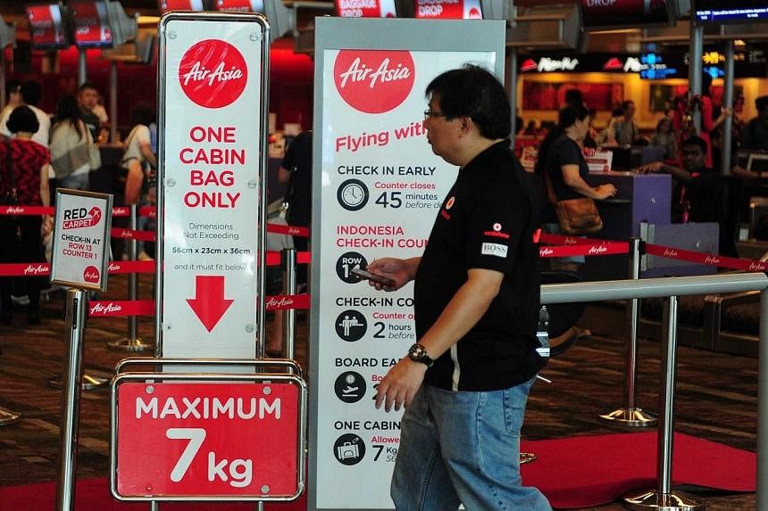 A man walking near the AirAsia check-in counter inside terminal 1 at Changi airport in Singapore on Dec 28, 2014. -- PHOTO: AFP