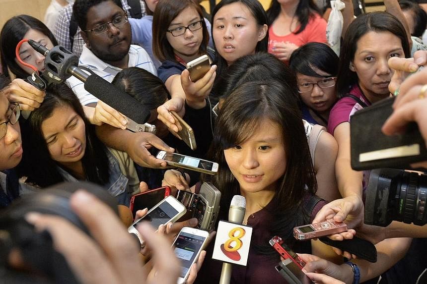 Louise Sidharta, 25, whose fiance was on the missing AirAsia flight QZ8501 speaking to the media outside the holding room for relatives and next-of-kin at Changi Airport Terminal 2, on Dec 28, 2014. -- ST PHOTO: DESMOND FOO