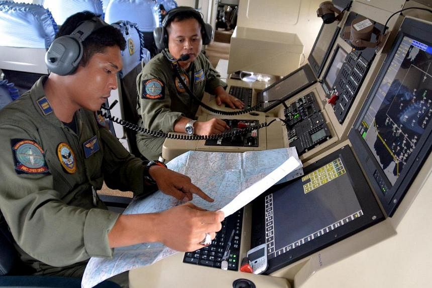 Two members of the Indonesian Navy's Tactical Commanding Operator (TACCO) help with the search for AirAsia flight QZ 8501 on board a CN235 aircraft over Karimun Java, in the Java Sea on Dec 28, 2014 in this photo taken by Antara Foto. -- PHOTO: REUTE