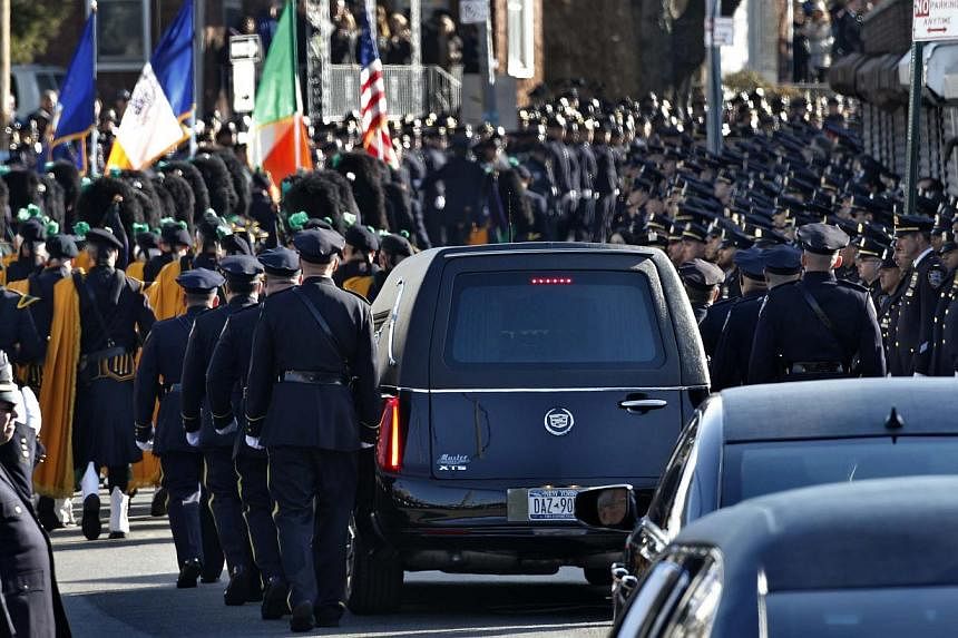A hearse carrying the casket containing the body of slain New York Police Department officer Rafael Ramos departs the Christ Tabernacle Church to it's final resting place in the Queens borough of New York Dec 27, 2014. -- PHOTO: REUTERS