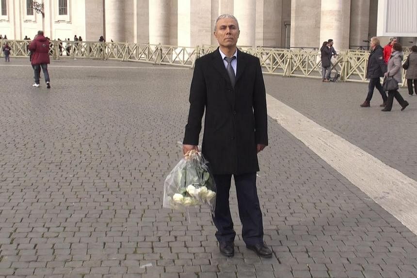 A handout photo taken from a video made and released by ADNKronos on Dec 27, 2014 shows Mehmet Ali Agca, the Turkish former extremist who attempted to assassinate Pope John Paul II in 1981, holding a wreath of flowers on St Peter's square in The Vati