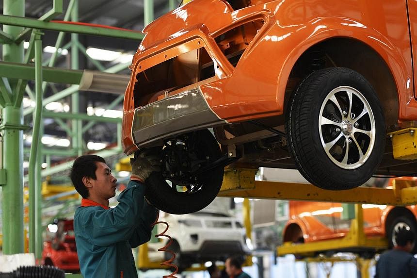 Workers assemble automobiles in a factory in Zouping, east China's Shandong province on Dec 16, 2014. The China National Bureau of Statistics will release the manufacturing PMI for December on New Year's Day. -- PHOTO: AFP