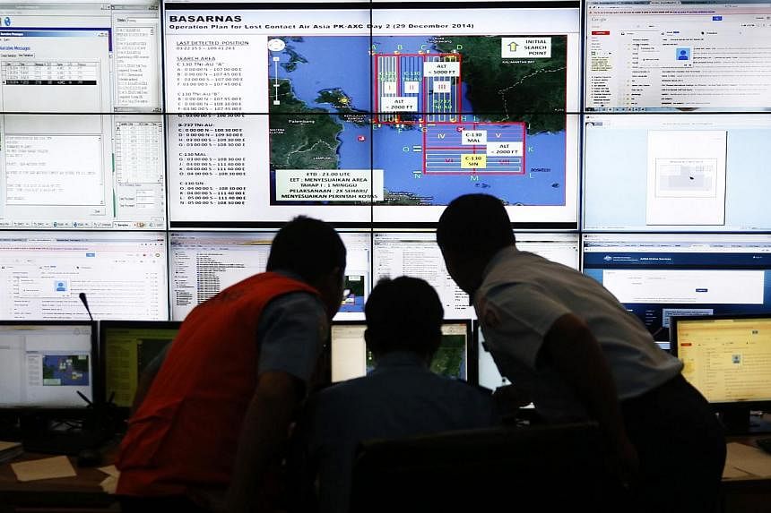 Authorities monitoring progress in the search for AirAsia Flight QZ8501 in the Mission Control Center inside the National Search and Rescue Agency in Jakarta on Dec 29, 2014. -- PHOTO: REUTERS