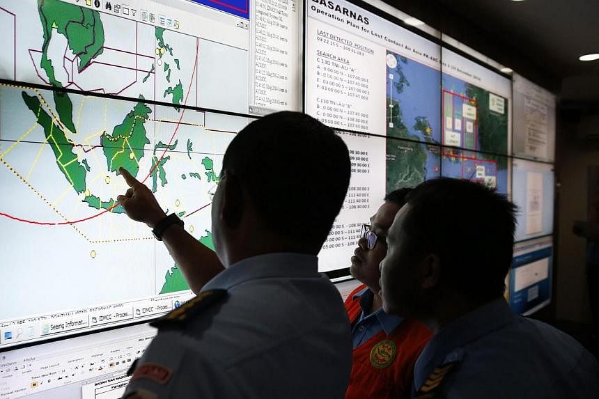 Military and rescue authorities monitor progress in the search for AirAsia Flight QZ8501 in the Mission Control Center inside the National Search and Rescue Agency in Jakarta on Dec 29, 2014. -- PHOTO: REUTERS