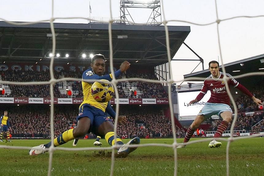 Arsenal's Danny Welbeck (second, right) shoots to score a goal against West Ham United during their English Premier League soccer match at Upton Park in London. -- PHOTO: REUTERS