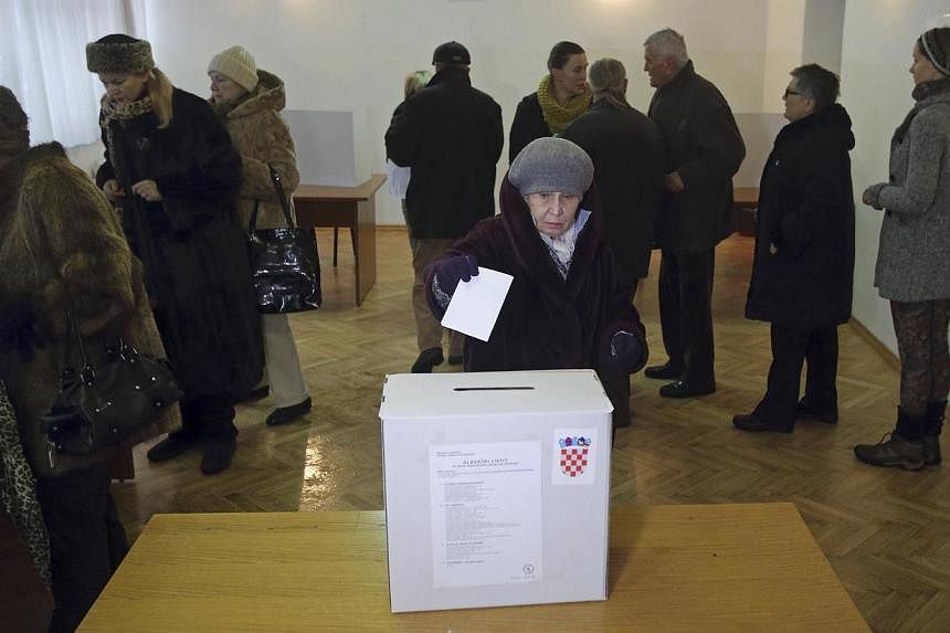 A woman casts her ballot at a polling station during the presidential election in Zagreb on Dec 28, 2014. -- PHOTO: REUTERS