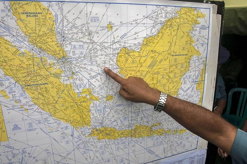 An Indonesian Air Force official shows a map to journalists of the search area for the missing AirAsia Indonesia flight QZ8501, at the airport in Surabaya, East Java, on Dec 29, 2014. -- PHOTO: AFP