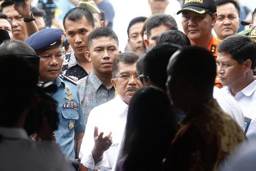 Indonesian Vice-President Jusuf Kalla (centre) speaking to AirAsia CEO Tony Fernandez (blocked) upon his arrival at the crisis centre at Juanda International Airport Terminal 2 on Dec 29, 2014. -- ST PHOTO: KEVIN LIM