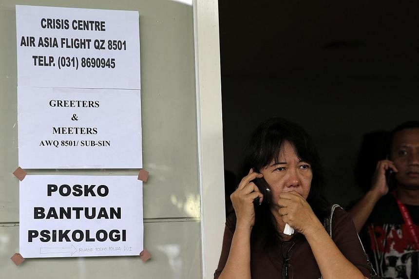 A family member of passengers onboard the missing AirAsia flight QZ8501 speaks on her mobile phone as she awaits news of the airplane at a waiting area in Juanda International Airport, Surabaya on Dec 29, 2014. -- PHOTO: REUTERS