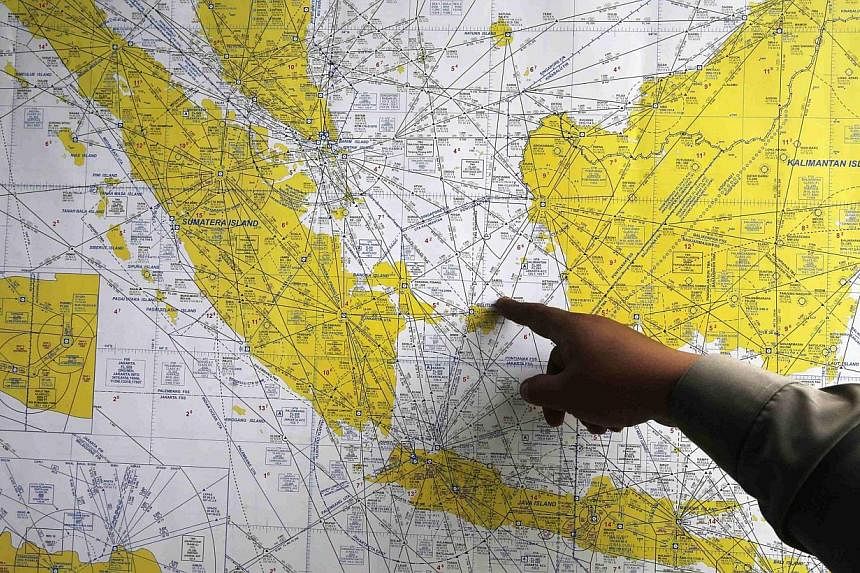 An Indonesian policeman points at a map of Indonesia at a crisis centre in Juanda International Airport, Surabaya Dec 29, 2014. -- PHOTO: REUTERS