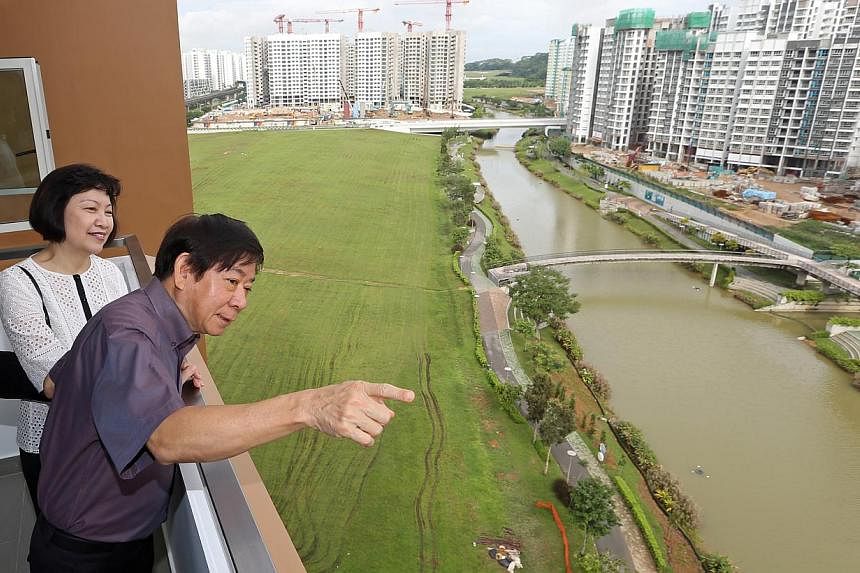 Mr Khaw Boon Wan and HDB chief executive Cheong Koon Hean viewing the projects along Punggol Waterway from a newly completed five-room flat yesterday, when Mr Khaw attended the handover of a block in the Waterway Woodcress project. -- ST PHOTO: SEAH 