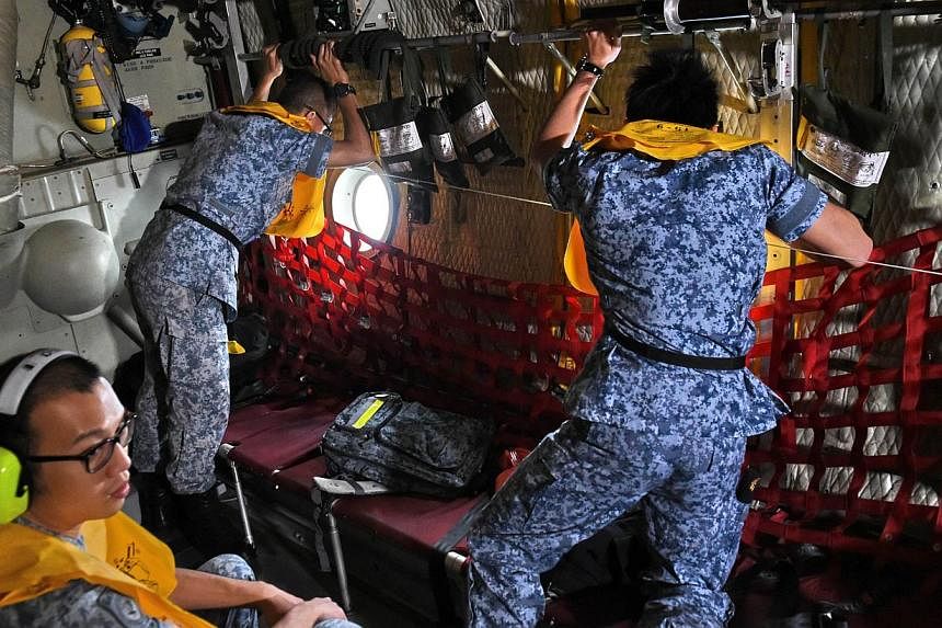 Republic of Singapore Air Force (RSAF) servicemen onboard a C-130 aircraft take part in the search and locate (SAL) operation for missing AirAsia flight QZ8501 over the Java sea on Dec 30, 2014. -- PHOTO: AFP