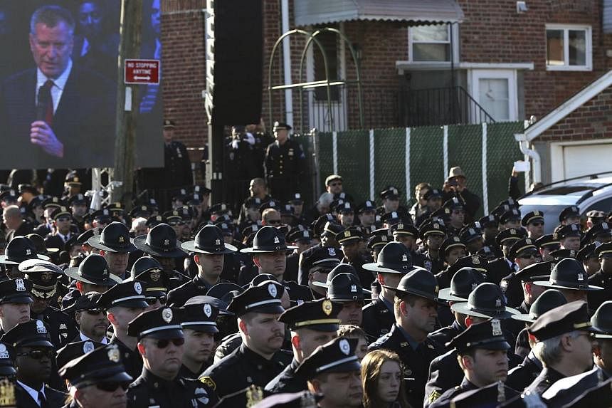 Law enforcement officers turn their backs on a video monitor as New York City Mayor Bill de Blasio speaks during the funeral of slain New York Police Department officer Rafael Ramos on Dec 27, 2014. De Blasio drew heckles and boos as well as cheers o