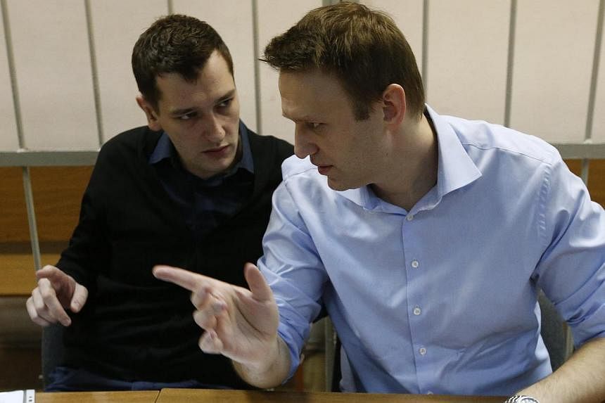 Russian opposition leader and anti-corruption blogger Alexei Navalny (right) talks to his brother and co-defendant Oleg before a court hearing in Moscow on Dec 19, 2014.&nbsp;A Russian court ruled on Tuesday, Dec 30, 2014, to give Alexei Navalny a su