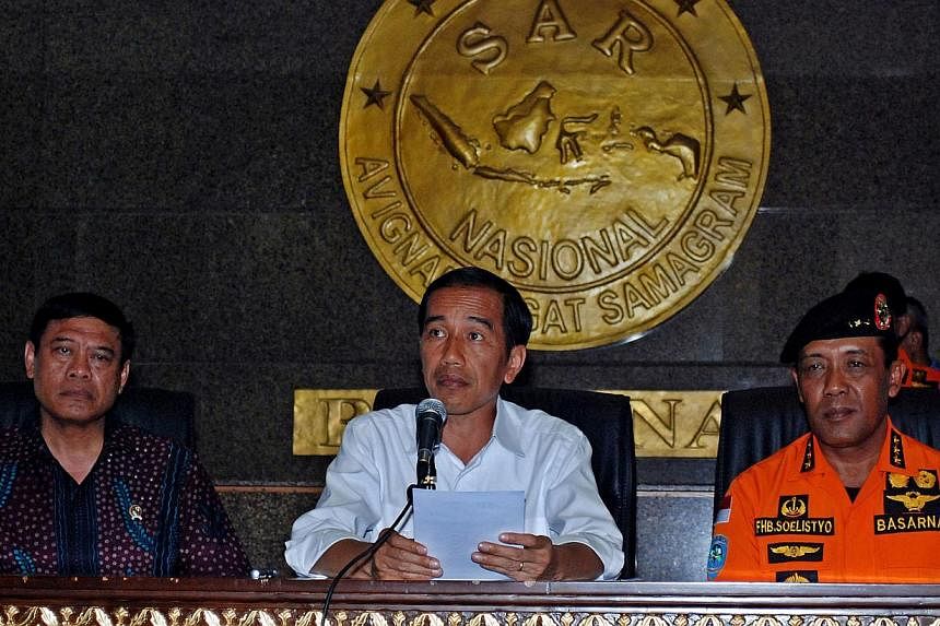 Indonesia's President Joko Widodo (centre) said recovering the remains of victims and debris will remain the topmost priority of the search and rescue operations team out at sea near the crash site of AirAsia flight QZ8501.&nbsp;-- PHOTO: AFP