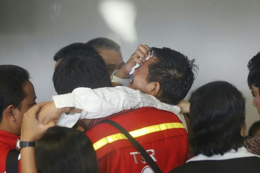 A family member being carried out of the crisis centre at Juanda International Airport Terminal 2 in Surabaya after watching first footages of a dead body found on Dec 30, 2014. -- ST PHOTO: KEVIN LIM
