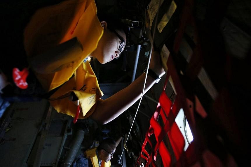 Republic of Singapore Air Force personnel survey the waters during a search and locate operation for the missing AirAsia QZ8501 plane at an undisclosed search area on Dec 30, 2014. Singapore air accident experts will depart on Wednesday morning to as