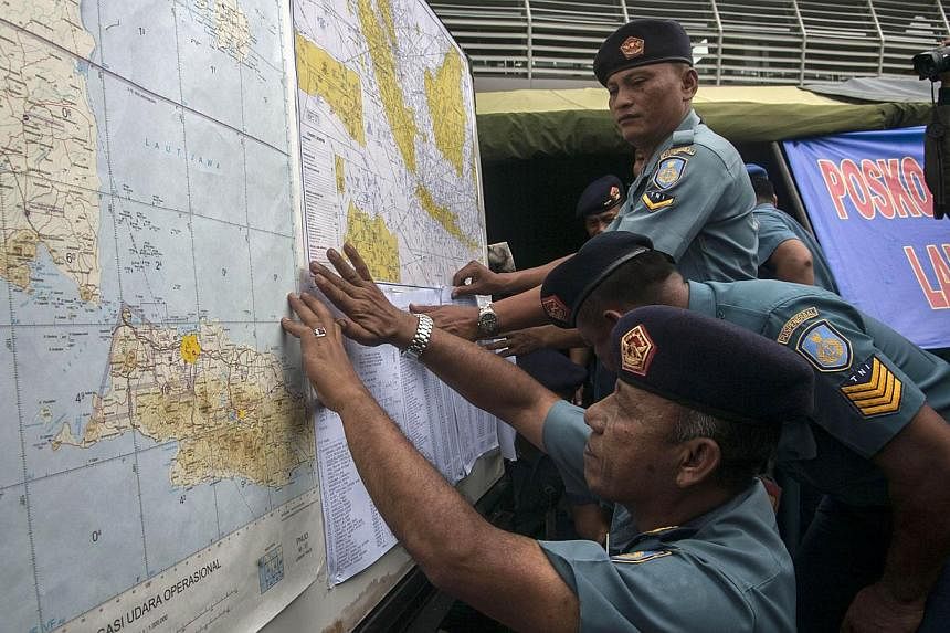 Indonesian Air Force officials show maps to journalists of the search area for the missing Malaysian air carrier AirAsia Flight QZ8501, at the airport in Surabaya, East Java, on Dec 29, 2014.&nbsp;&nbsp;Indonesia has asked the United States for help 