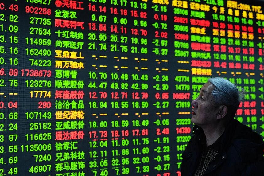A stock investor checking the share prices at a security firm in Hangzhou. -- PHOTO: AFP
