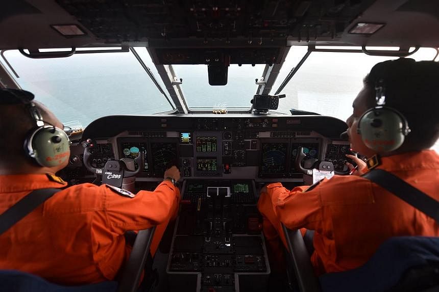 Pilots of the Indonesian air force keeping a look out during search operations for the missing AirAsia flight QZ8501, in Pangkalan Bun, Central Kalimantan on Dec 30, 2014. -- PHOTO: AFP