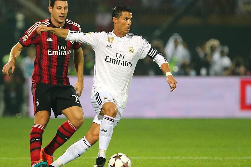 Real Madrid's forward Cristiano Ronaldo (right) vies for the ball against AC Milan's defender Daniele Bonera during their friendly football match on Dec 30, 2014 at the Sevens Stadium in Dubai. -- PHOTO: &nbsp;AFP