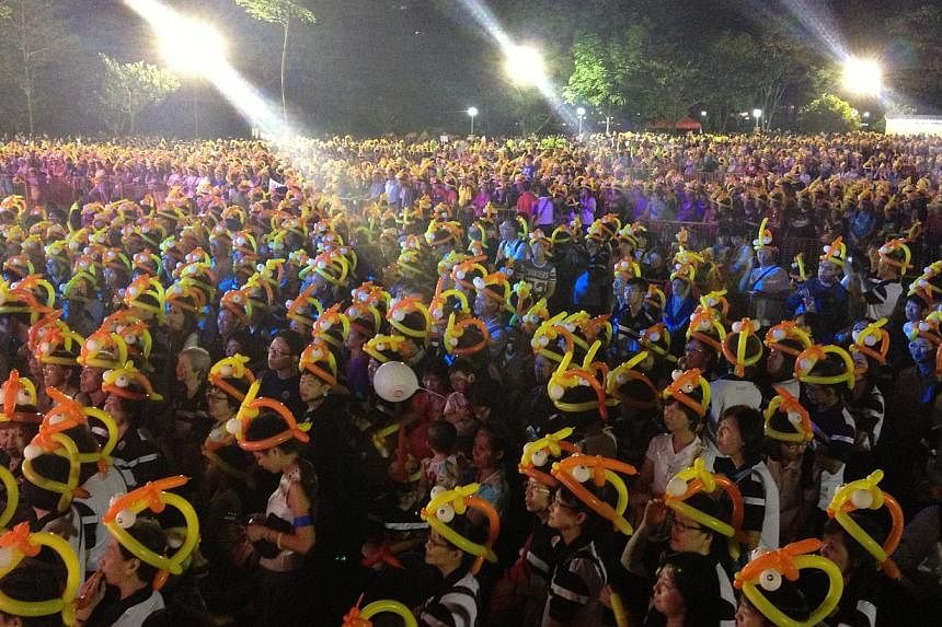 Ang Mo Kio GRC residents gather at the grand lawn at Bishan-Ang Mo Kio park in an attempt to break the world record for most number of people wearing balloon hats with 12,000 balloon hats on Dec 31, 2014, as part of the New Year's Eve celebrations. -