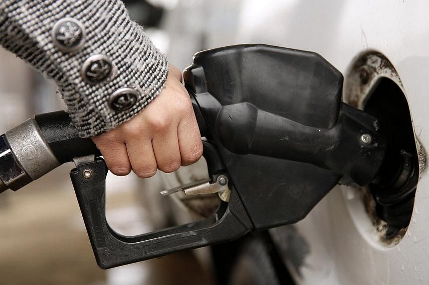 A woman pumping petrol at a station in Falls Church, Virginia on Dec 16, 2014. The US government has granted permission to "some" companies to sell lightly treated condensate abroad. -- PHOTO: REUTERS