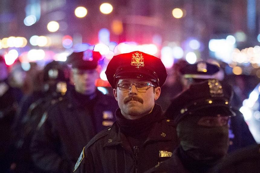 Police watch over a protest march against police brutality that traveled from Union Square to Times Square on Dec 31, 2014, in New York City. -- PHOTO: AFP