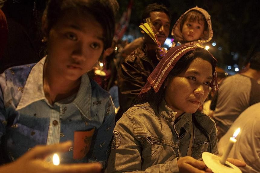 Indonesians hold up candles during a candle light vigil for the victims of AirAsia flight QZ8501 at Surabaya Dec 31, 2014. -- PHOTO: REUTERS