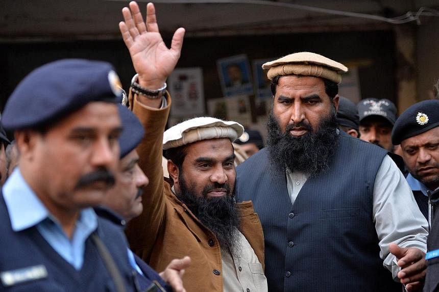 Pakistani security personnel escort Zaki-ur-Rehman Lakhvi (centre), the alleged mastermind of the 2008 Mumbai attacks, as he leaves court after a hearing in Islamabad on Jan 1, 2015. A Pakistani court on Thursday sent the alleged mastermind of the 20