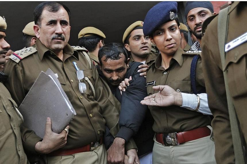 Policemen escort driver Shiv Kumar Yadav (centre in black jacket), an Uber taxi driver who is accused of a rape, outside a court in New Delhi Dec 8, 2014. The&nbsp;woman who was allegedly raped by Yadav said on Thursday, Jan 1, 2015, that she has sto