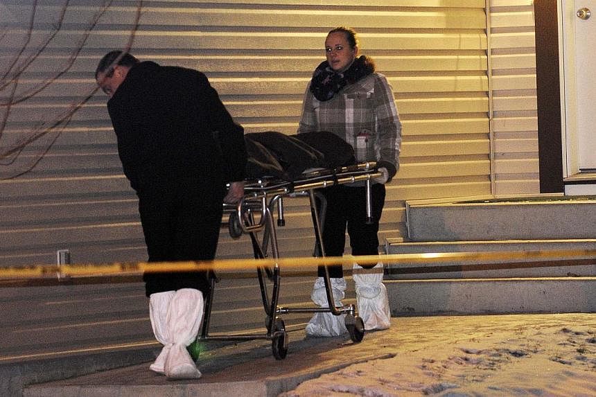 Members of the coroner's office remove a body from one of three crime scenes where a total of nine people were found dead on Dec 30, 2014.&nbsp;The suspected killer of eight people in the Canadian city of Edmonton had a criminal record dating back to