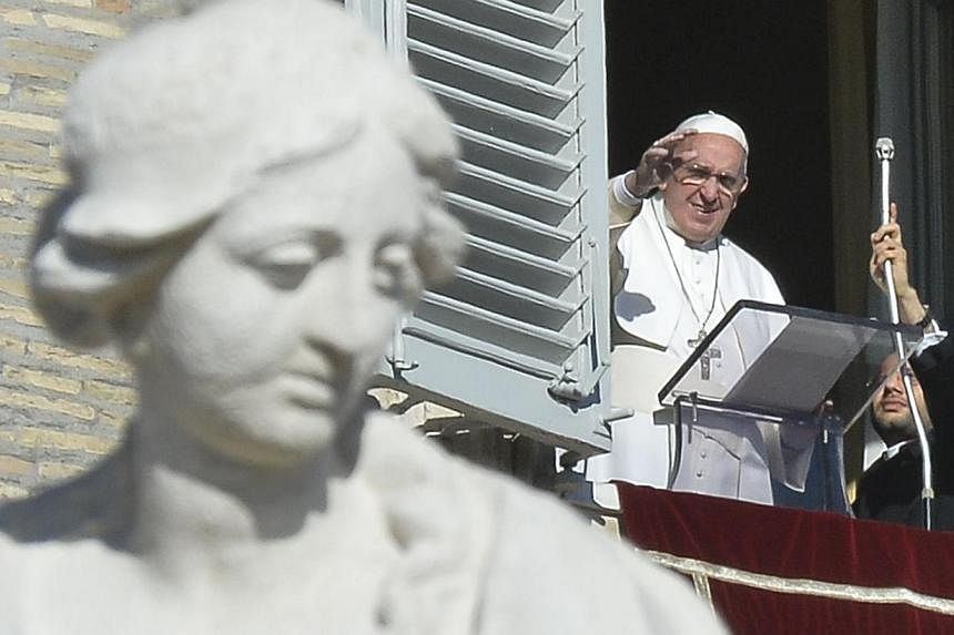 Pope Francis greeting the crowd from the window of the Apostolic Palace overlooking St.Peter's Square during his Angelus prayer on Jan 1, 2015 at the Vatican. -- PHOTO: AFP&nbsp;