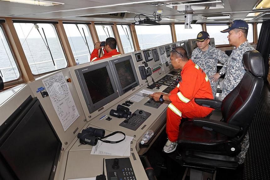 Major Wee Hong Tat, Major John Lau and 2nd Officer Ronald Tecson at the bridge of the MV Swift Rescue. -- ST PHOTO:&nbsp;SEAH KWANG PENG