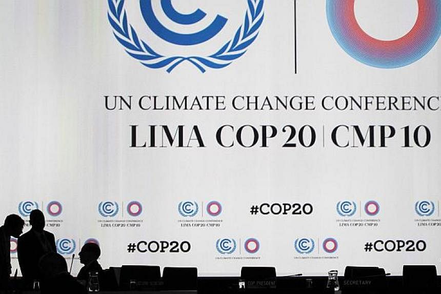 Delegates talk during a break at a plenary session of the UN Climate Change Conference in Lima, Peru, on Dec 12, 2014. -- PHOTO: REUTERS
