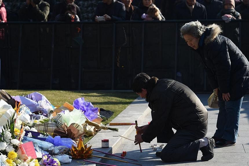 A couple burning incense &nbsp;on Jan 2, 2015,&nbsp;at the site of a New Year's Eve stampede at the Bund in Shanghai. -- PHOTO: AFP&nbsp;