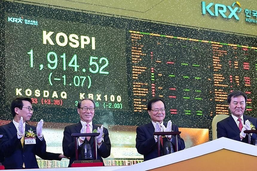 South Korea's Financial Services Commission chairman Shin Je Yoon (right) and officers marking the opening of the stock market in the new year at the Korea Exchange in Seoul on Jan 2, 2015. -- PHOTO: AFP
