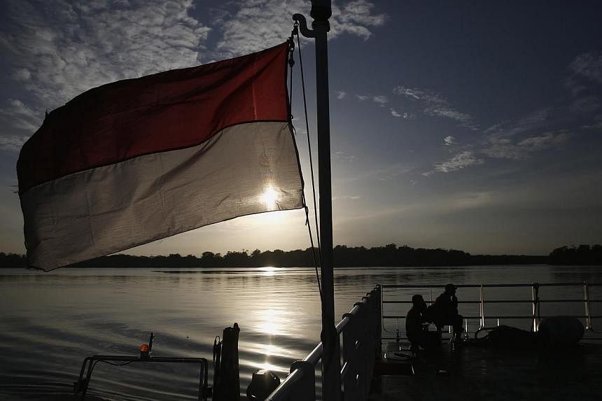 An Indonesian national flag is seen on the deck of SAR ship Purworejo during a search operation for passengers onboard AirAsia flight QZ8501, in the Java Sea, Indonesia on Jan 2, 2015. -- PHOTO: REUTERS