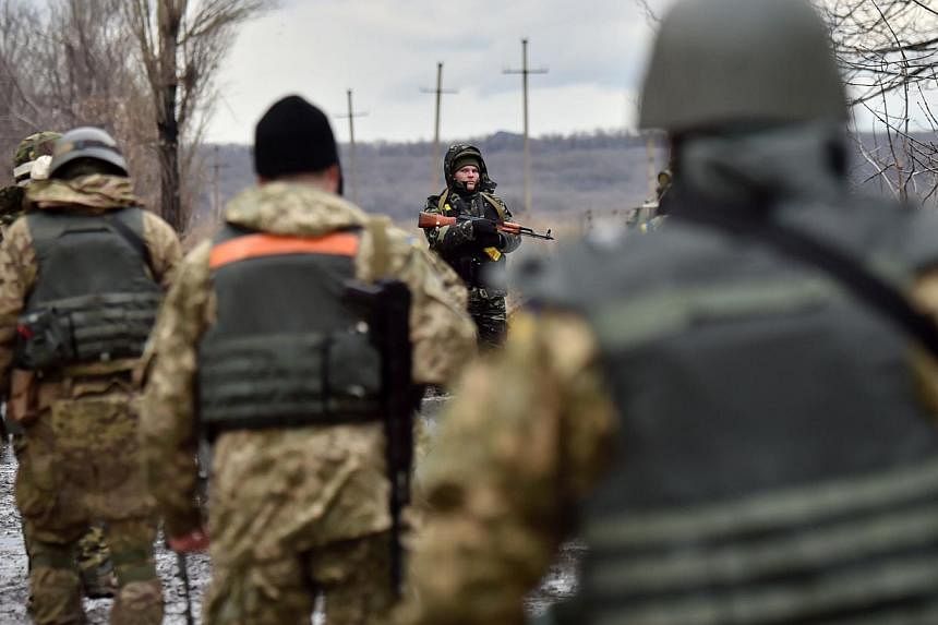 Ukrainian soldiers gather close to the frontline in the eastern Ukrainian city of Debaltseve, Donetsk region, on Dec 24, 2014. -- PHOTO: AFP