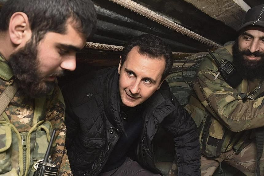 Syrian President Bashar al-Assad (centre) talks to soldiers during a visit to Jobar, north-east of Damascus, in this handout photograph distributed by Syria's national news agency Sana on Jan 1, 2015. He&nbsp;thanked soldiers fighting "in the face of