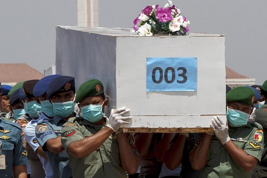 Indonesian military personnel&nbsp;at a military base in Surabaya&nbsp;carrying &nbsp;on Jan 1, 2015,&nbsp;a casket containing the body of an AirAsia flight QZ8501 passenger, recovered off the coast of Borneo. -- PHOTO: REUTERS