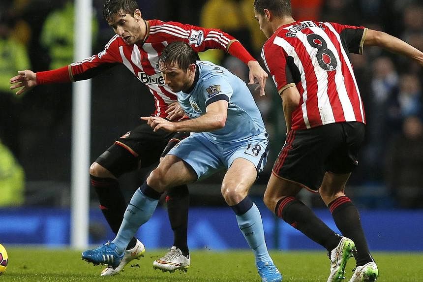 Manchester City's Frank Lampard (centre) is challenged by Sunderland's Ricardo Alvarez (left) and Jack Rodwell during their English Premier League soccer match at the Etihad Stadium in Manchester, northern England Jan 1, 2015. -- PHOTO: REUTERS