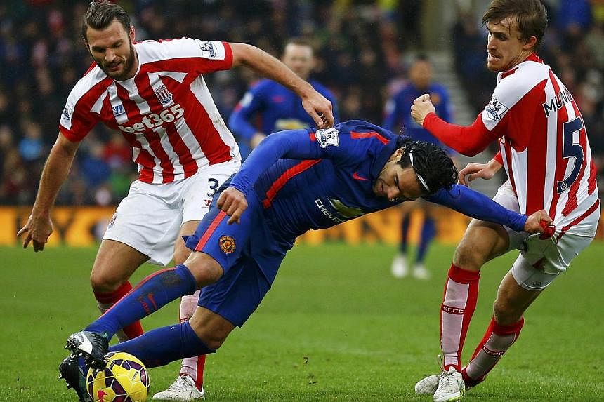 Manchester United's Radamel Falcao (centre) is challenged by Stoke City's Erik Pieters (left) and Marc Muniesa during their English Premier League soccer match at the Britannia Stadium in Stoke-on-Trent, central England Jan 1, 2015. -- PHOTO: REUTERS