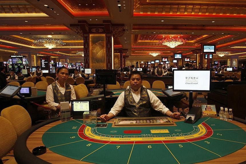 Croupiers at gaming tables inside a casino at Sands Cotai Central in Macau in this 2012 file photo. Gambling revenue inf Macau, the world's biggest gambling hub, fell 2.6 per cent last year. -- PHOTO: REUTERS